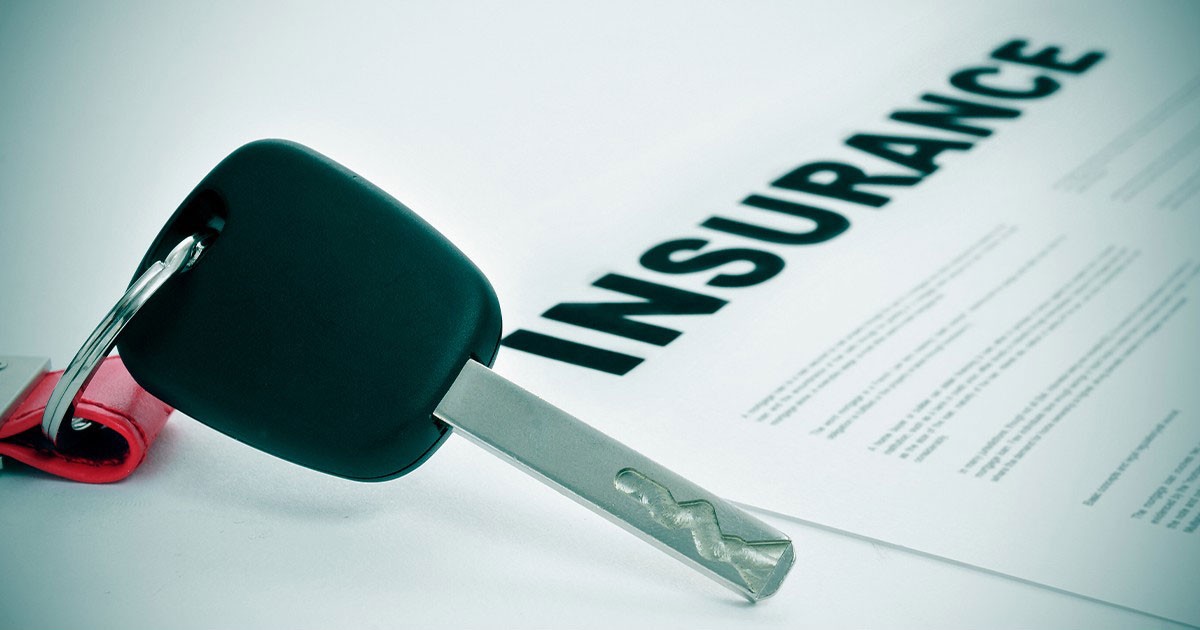 Car key on an insurance document with the word "INSURANCE" prominently displayed.