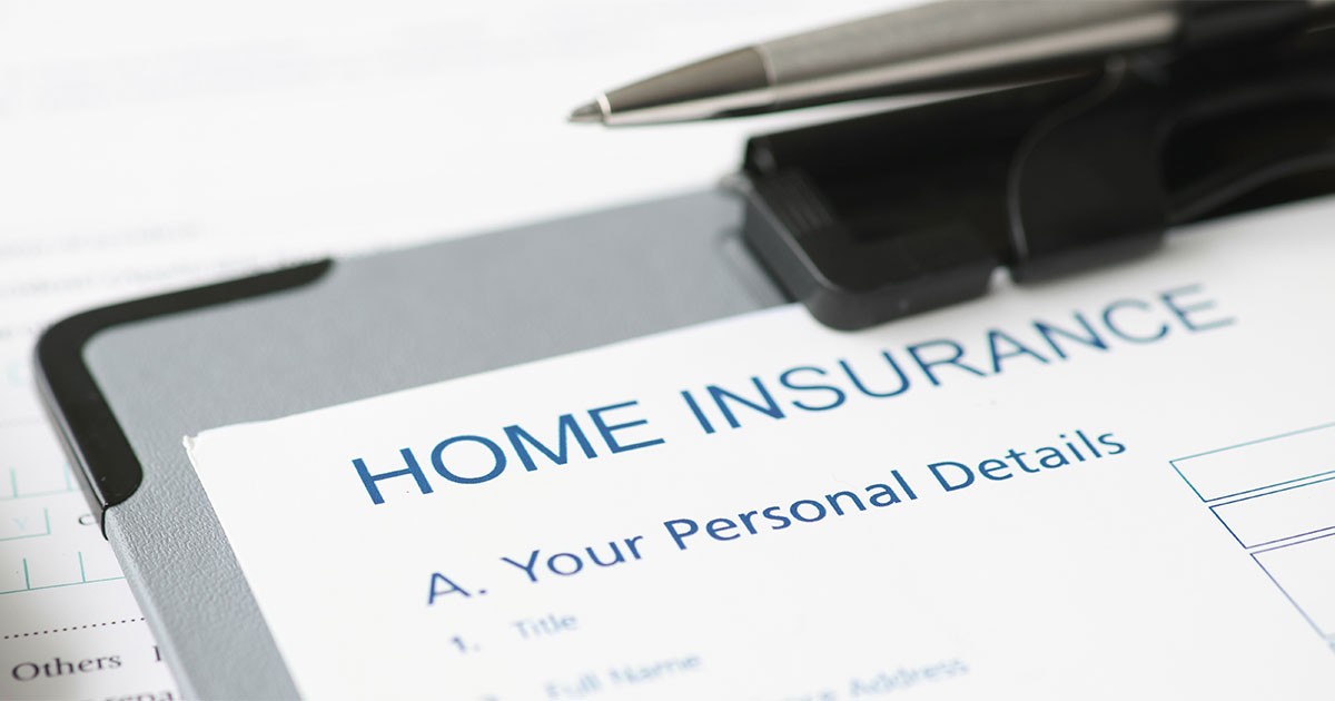 Close-up of a home insurance document on a clipboard with a pen attached.